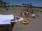 One good sunny day me, Zhanna, Lyuba and my friends Anna and Jury with their children went to one lovely beach of the lake Issyk-Kul in the area of Mayak village. We found a quiet perfect place and put some kind of awning to protect Lyuba against the sun. At the photo from left to right: Lyuba under the tent, Zhanna is sunburning, Anna and Jury are sitting on the bedspreads.