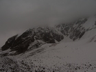 The view of Djigit peak bottom covered with clouds. A lot of snow on the slopes of these mountains in this year.