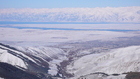 The view of Karakol town and the entrance of Karakol gorge from 2750m altitude of ski route in Kashka-Suu valley. All the town is clearly visible same as the road that goes to ski-base.