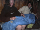 Girls were sitting in the hut around the fire trying to get wet clothes dry. Left to right: Christine, speeping bag, Valerie.