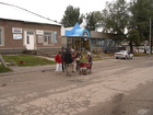 Going back from the market we met the old woman with baby carriage full of flowers on the Lenina street of Karakol. The guys surrounded woman trying to talk with her and take some photographs.