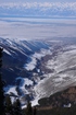 Amazing view of Karakol Valley from ski base Karakol route. At the photo you can see the road, frozen Karakol river, part of Karakol town and Issyk-Kul Lake.