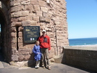 На входе в замок Бамбург (Bamburgh Castle) висит табличка на которой написаны часы работы (когда он открыт для посетителей), а также приписка, что вход с собаками запрещен. На фото: Люба и я.